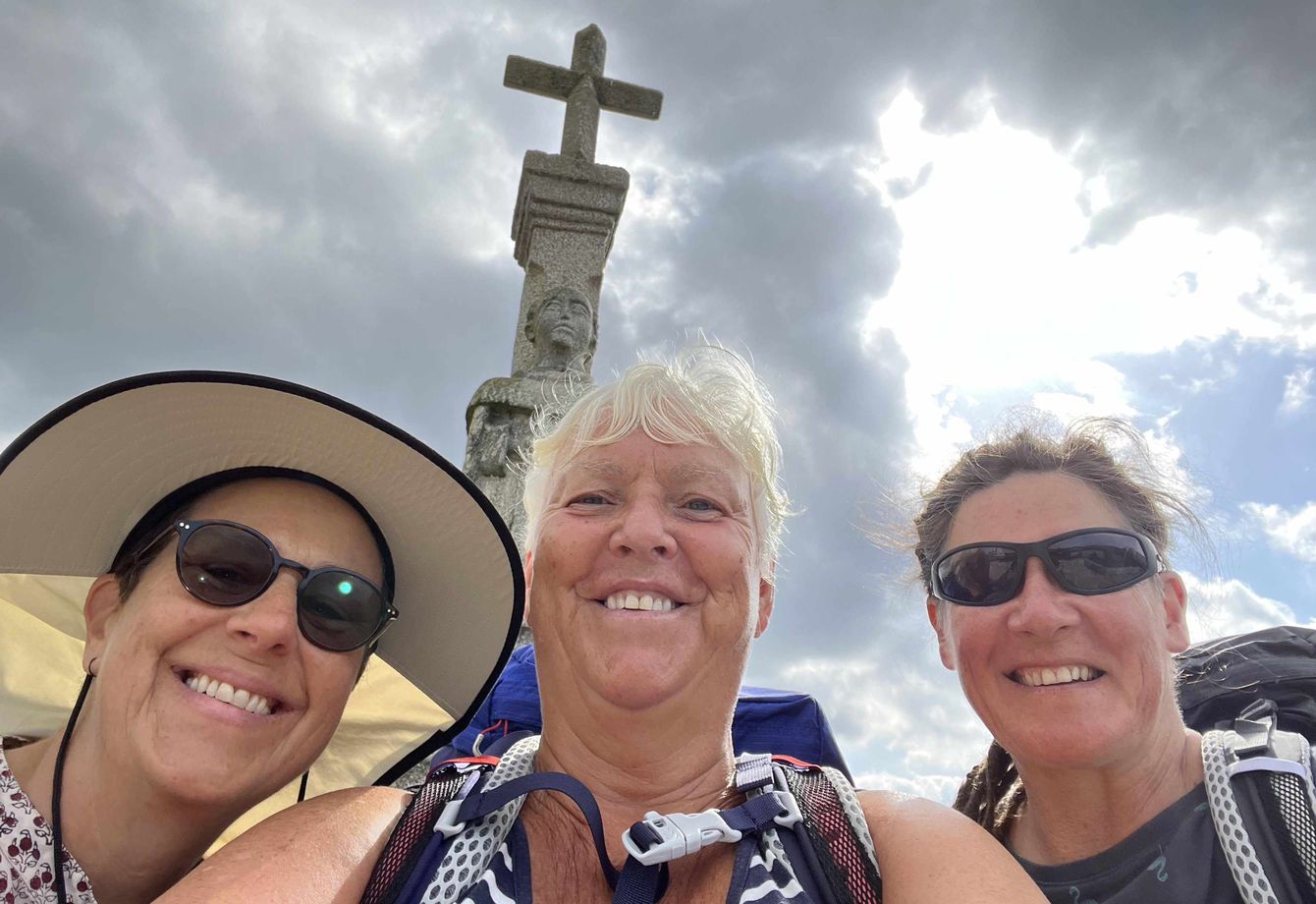 Centre visitor Mary, taking selfie and smiling with two friends doing Camino de Santiago