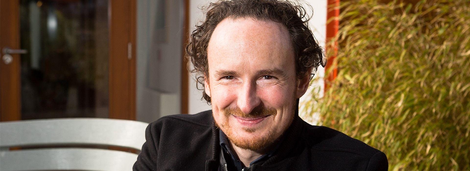 Headshot of Rhys with Maggie's centre garden in background