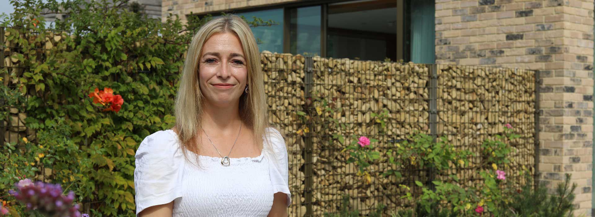 Hannah smiling and standing outside our Wirral centre